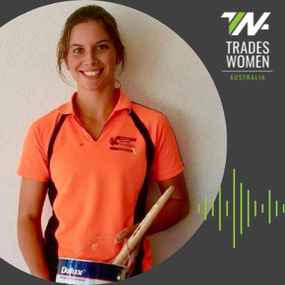 Alisha Alisha wearing a hi-vis shirt and holding a paint can and smiling