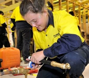 Young woman, plumber, work clothes
